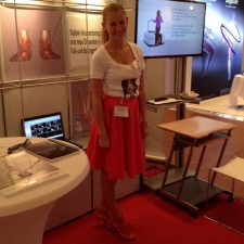 Laura arbeitet als Verteilung von Produktprospekten an Ärzte als Modelhostess eines Herstellers von Computertomografie-Geräten auf der Messe